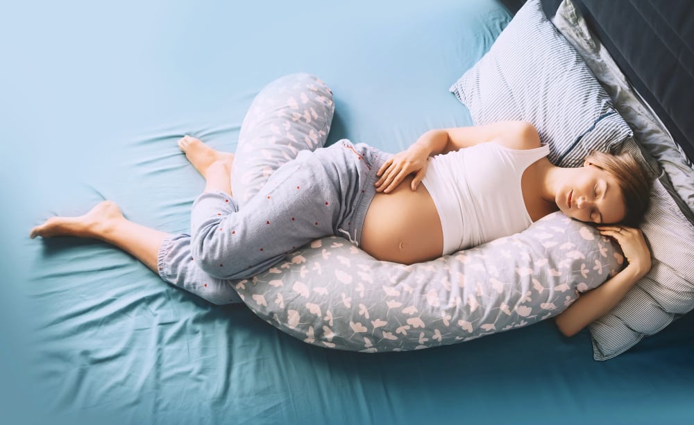 Bonne position pour dormir avec un coussin d'allaitement entre les jambes